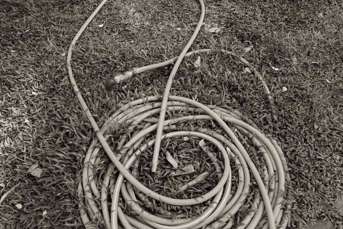 A coiled water hose beside a campsite utility connection